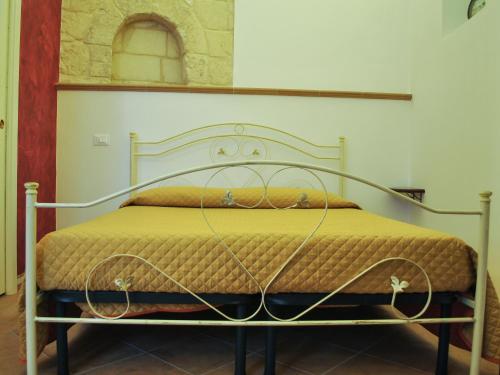 カステッラネータにあるB&B LuiRòの金属製のフレーム付きベッド(黄色の掛け布団付)