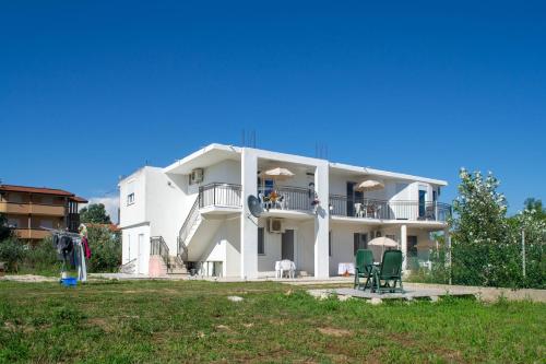 a large white building with people sitting on the balcony at Aida Apartments in Ulcinj