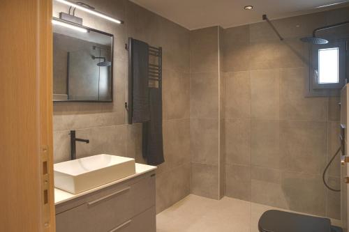 a bathroom with a sink and a mirror and a shower at Philippos & Alexandros Apartments in Tigaki