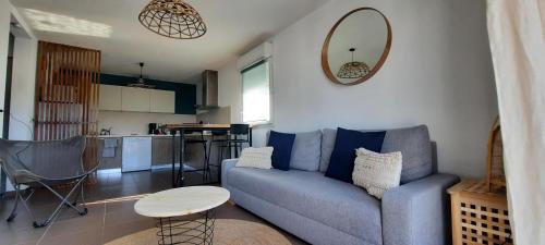 un salon avec un canapé bleu et une table dans l'établissement Cosy T3 gare Terrasse + parking, à Sète