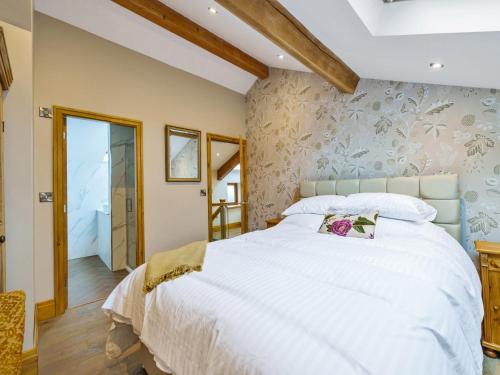 a bedroom with a large white bed in a room at The Barn in Holmfirth