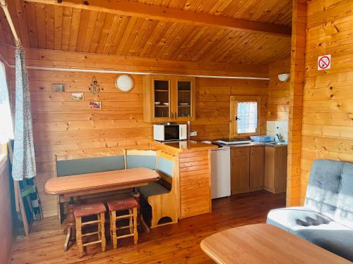 a small kitchen with a table in a cabin at Lazur domki wypoczynkowe in Dźwirzyno