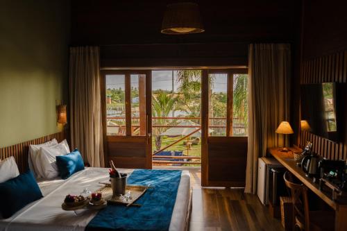 a hotel room with a bed and a balcony at VILA ATY LODGE in Atins