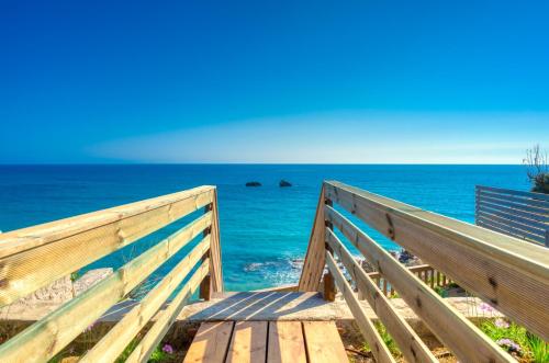 a wooden boardwalk leading to the beach at Villa Angela in Ágios Matthaíos