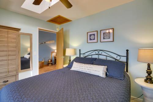 1 dormitorio con 1 cama con edredón azul en House on Lake Mary with Boat Dock and Lakeside Beach!, en Alexandria