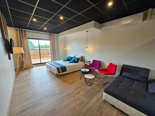 a bedroom with a bed and a couch and a chair at Aérogites Chambley in Dommartin-la-Chapelle