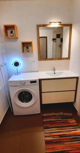 une salle de bain avec une machine à laver et un lavabo dans l'établissement Cosy T3 gare Terrasse + parking, à Sète