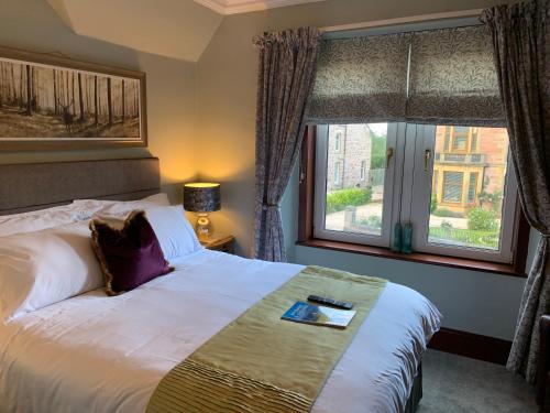 een hotelkamer met een bed en een raam bij Advie Lodge in Inverness