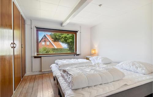 Duas camas num quarto com uma janela em Cozy Home In Allinge With Kitchen em Allinge