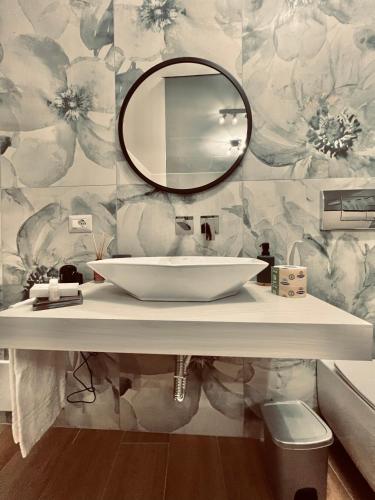 a bathroom with a white sink and a mirror at Akropoli Exclusive Room in Agrigento
