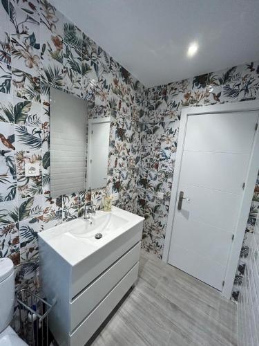 a bathroom with a sink and a toilet and a mirror at LA CASA DEL MUELLE in Avilés