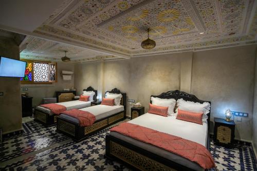 Hotel & Ryad DALILA في فاس: غرفة نوم بسريرين وسقف متهالك