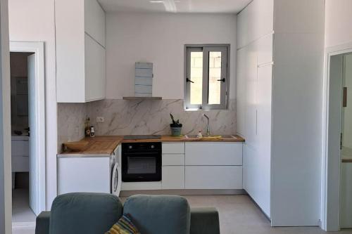 a kitchen with white cabinets and a stove top oven at Mimo’ s House in Vlorë