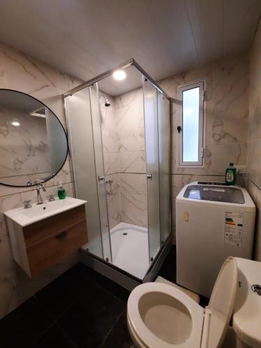 a bathroom with a shower and a toilet and a sink at Departamento Brown - zona centro in Mar del Plata