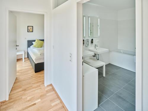 Baño blanco con cama y lavabo en MySchönbrunn Apartments, en Viena