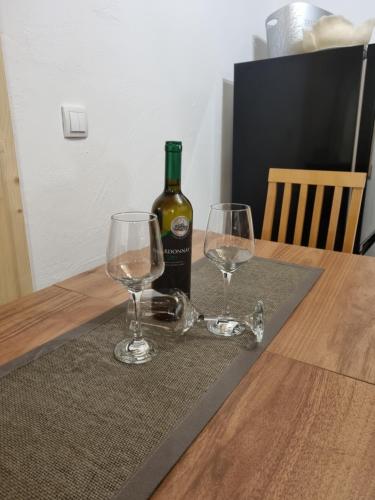 - une bouteille de vin et 2 verres à vin sur une table dans l'établissement Zvuk Tisine 1, à Valjevo