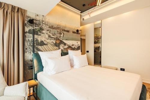 a bedroom with a white bed and a chair at Rosetti One in Constanţa