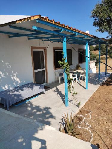 a patio with a blue pergola and a bed at Kea Guesthouse in Ioulida