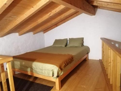 um quarto com uma cama num quarto com tectos em madeira em Monte Alentejano ideal para relaxar na natureza em São Teotónio