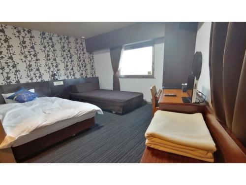 a hotel room with a bed and a desk and a television at Hotel AreaOne Minamisoma - Vacation STAY 56242v in Minamisouma