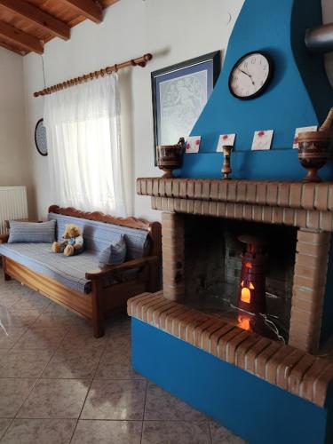 a living room with a fireplace with a clock at Kea Guesthouse in Ioulida