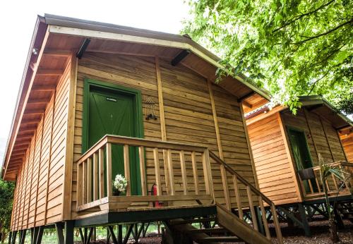 a log cabin with a green door and a porch at Ekinoks Hotel - Adults Only in Cıralı