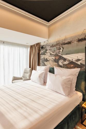 a bedroom with a large white bed with a painting on the wall at Rosetti One in Constanţa