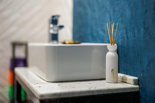 a white vase with bamboo sticks in it on a counter at Rosetti One in Constanţa