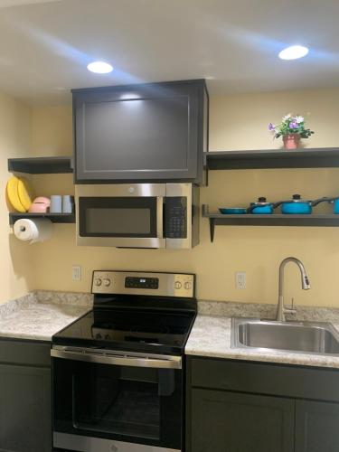 a kitchen with a microwave and a stove and a sink at Relax Inn of Medford in Medford