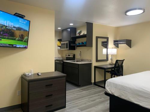 a hotel room with a bed and a kitchen at Relax Inn of Medford in Medford