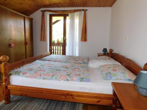 een slaapkamer met een bed met een houten frame en een raam bij Apartment Branko in Ptuj