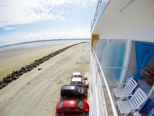 a group of cars parked on the beach at Hotel Crucero in Cojimíes