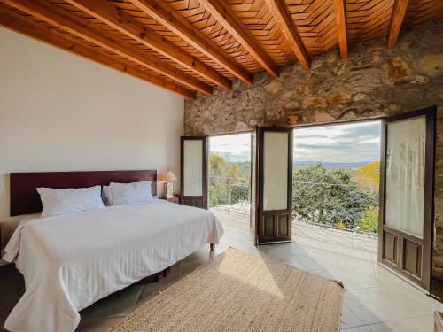 um quarto com uma cama grande e janelas grandes em Casa Liza em San Miguel de Allende