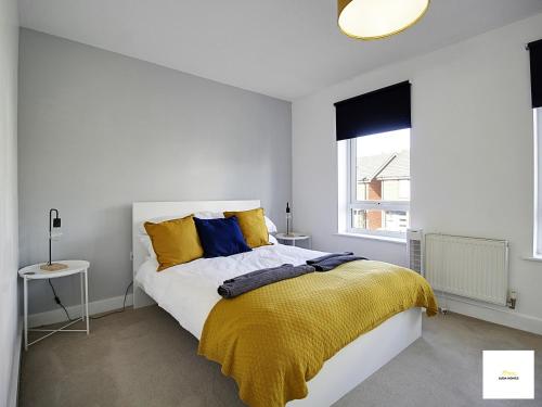 1 dormitorio con 1 cama con almohadas amarillas y azules en Reading 3 Bedroom Close to all Amenities w/Parking, en Reading
