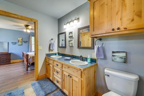 La salle de bains est pourvue de toilettes, d'un lavabo et d'un miroir. dans l'établissement Magical Pineville Oasis Gas Grill and Scenic Deck!, 