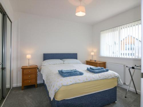 a bedroom with a bed with two blue towels on it at 1 Westenra Gardens in Peterhead