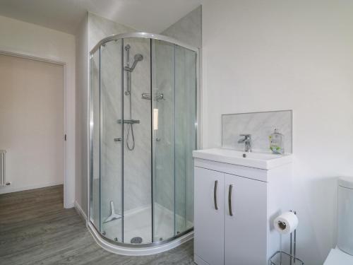 a bathroom with a glass shower and a sink at 1 Westenra Gardens in Peterhead