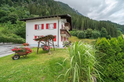 a house with a wheelbarrow in front of it at Alpenhaus Thurnher in Gaschurn