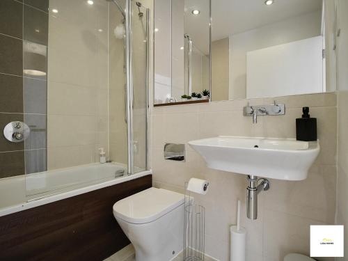 Baño blanco con lavabo y aseo en Reading 3 Bedroom Close to all Amenities w/Parking, en Reading