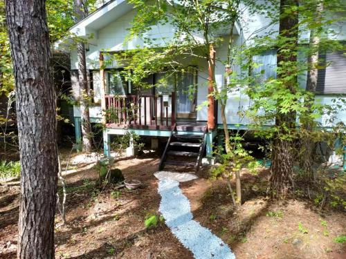 a house with a porch in the woods at Mori no Komei campsite - Vacation STAY 04499v in Kita-karuizawa