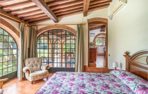 Schlafzimmer mit einem Bett, einem Stuhl und Fenstern in der Unterkunft I Cipressi in Bibbona