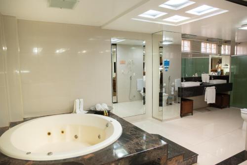 y baño grande con bañera y ducha. en Hotel Village Premium Caruaru, en Caruaru