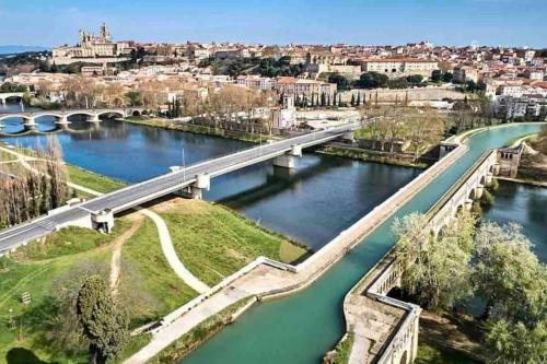 a bridge over a river with a city in the background at Le Berlioz-Studio-Clim-Wifi-Balcon in Béziers