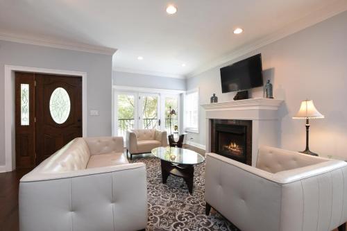 a living room with white furniture and a fireplace at Luxury Home near Wrigley, Boystown & Andersonville in Chicago