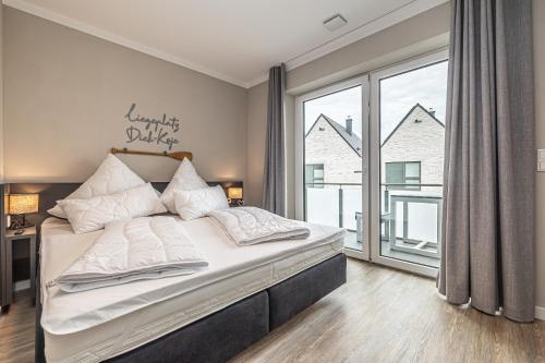 1 dormitorio con cama grande y ventana grande en Diek-Koje, en Büsum