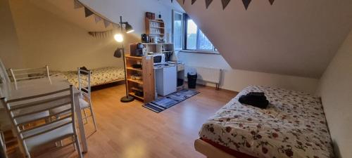 a small room with a bed and a refrigerator at Chambre d'Hôtes R&S in Bemont