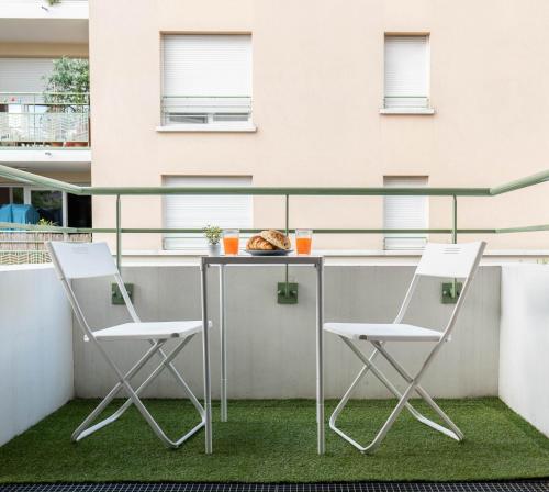 two chairs and a table on a balcony at Golden Location in Bagnolet