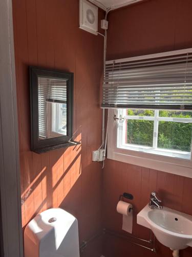 a bathroom with a sink and a toilet and a window at The View Guesthouse at Ekeberg -10 min by tram to Oslo S in Oslo