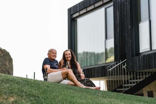 a man and a woman sitting on the side of a building at Stock & Stein Lodges in Bad Gleichenberg