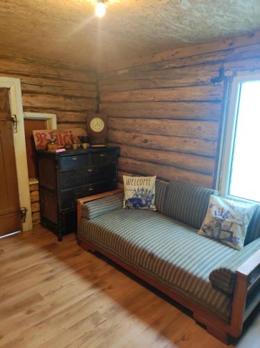 a couch in a room with a wooden wall at Bluci seksti in Seksti